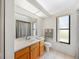 Bright bathroom with white sink, toilet, window, towel rack and tan-tiled floor at 6194 Sanderling Dr, Lakeland, FL 33809