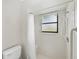 Bright bathroom with tiled shower, handheld shower head, window, and safety bar at 6194 Sanderling Dr, Lakeland, FL 33809