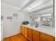 Bathroom with long vanity, oak cabinets, stylish mirror and attractive decor at 6194 Sanderling Dr, Lakeland, FL 33809