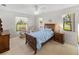 Charming bedroom featuring large windows, a wooden bed frame, and a cozy atmosphere at 6194 Sanderling Dr, Lakeland, FL 33809