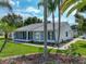 Charming single-story home with white siding, manicured lawn, and mature palm trees adding to the curb appeal at 6194 Sanderling Dr, Lakeland, FL 33809