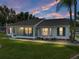 Well-lit single-story home at dusk, featuring a screened-in porch perfect for enjoying tranquil evenings at 6194 Sanderling Dr, Lakeland, FL 33809