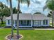 Quaint single-story home with white exterior, complemented by a well-kept lawn and inviting front porch at 6194 Sanderling Dr, Lakeland, FL 33809