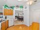 Kitchen features wood cabinets, white appliances, and an open view to the dining area with fireplace at 6194 Sanderling Dr, Lakeland, FL 33809