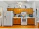 Kitchen features white appliances, wood cabinets and modern cooking appliances at 6194 Sanderling Dr, Lakeland, FL 33809