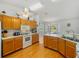 Kitchen with wood cabinets, white appliances, and a view into the dining room at 6194 Sanderling Dr, Lakeland, FL 33809