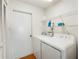 Functional laundry area with shelving, washer, and dryer, located near a doorway at 6194 Sanderling Dr, Lakeland, FL 33809