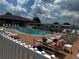 Community outdoor pool surrounded by lounge chairs with a blue sky background at 6194 Sanderling Dr, Lakeland, FL 33809
