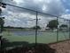 A view of outdoor tennis courts with full fencing and lighting at 6194 Sanderling Dr, Lakeland, FL 33809