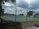 A view of outdoor tennis courts with full fencing and lighting at 6194 Sanderling Dr, Lakeland, FL 33809