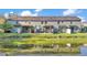 A view of a townhouse backyard with screened enclosures, patio furniture, and a scenic pond at 6435 Sedgeford Dr, Lakeland, FL 33811