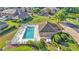 An aerial view of a community pool with lounge chairs and a clubhouse, surrounded by greenery at 6435 Sedgeford Dr, Lakeland, FL 33811