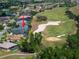 Aerial shot of a house adjacent to a golf course featuring lush green fairways and a sand trap at 645 Whisper Woods Dr, Lakeland, FL 33813