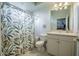 Bathroom with white cabinets, white toilet, vanity and shower with decorative curtain at 645 Whisper Woods Dr, Lakeland, FL 33813