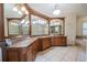 Luxurious bathroom featuring an expansive vanity with double sinks, elegant lighting, and a separate glass-enclosed shower at 645 Whisper Woods Dr, Lakeland, FL 33813