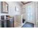 Quaint bathroom with an ornate vanity, decorative wallpaper, and a door leading to the outdoors at 645 Whisper Woods Dr, Lakeland, FL 33813