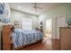 Comfortable bedroom with wood floors, ceiling fan, and ensuite bathroom with a shower and toilet at 645 Whisper Woods Dr, Lakeland, FL 33813