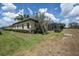 Spacious backyard with lush lawn and screened lanai offering serene views of the surrounding landscape at 645 Whisper Woods Dr, Lakeland, FL 33813