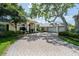 Stunning exterior view of the home with a three-car garage, mature trees, and a brick-paved driveway at 645 Whisper Woods Dr, Lakeland, FL 33813