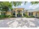 Elegant single-story home featuring a grand entrance, lush landscaping, and a spacious circular driveway at 645 Whisper Woods Dr, Lakeland, FL 33813