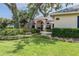 Charming home with mature landscaping, stone bench, and lush green lawn, exuding curb appeal and inviting comfort at 645 Whisper Woods Dr, Lakeland, FL 33813