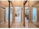 Hallway featuring mirrored closet doors and glimpses into bathrooms with vanities and a soaking tub at 645 Whisper Woods Dr, Lakeland, FL 33813