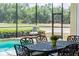 Outdoor dining by the screened pool with beautiful golf course views, ideal for relaxation at 645 Whisper Woods Dr, Lakeland, FL 33813