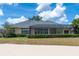 A home with a screened lanai overlooking a well-manicured lawn and lush landscaping provides a serene outdoor living space at 645 Whisper Woods Dr, Lakeland, FL 33813