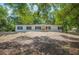 Charming single story home with black shutters and a wooden porch nestled amongst mature trees at 6527 Fernwood Dr, Lakeland, FL 33810