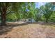 Home exterior with a large yard and mature trees, providing a serene and private setting at 6527 Fernwood Dr, Lakeland, FL 33810