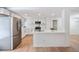 Modern kitchen with stainless steel appliances, white cabinets, quartz counters, and laminate flooring at 6527 Fernwood Dr, Lakeland, FL 33810