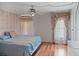 Bedroom featuring a ceiling fan, floral details, and a window, offering a cozy feel at 6731 Canterbury Ne Dr, Winter Haven, FL 33881
