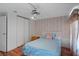 Cozy bedroom with wood-look floors, closet, and ceiling fan, bathed in soft natural light at 6731 Canterbury Ne Dr, Winter Haven, FL 33881