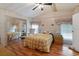 Bedroom with wood-look floors, ceiling fan, and a mirrored closet for storage at 6731 Canterbury Ne Dr, Winter Haven, FL 33881