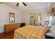 Bedroom with a yellow checkered comforter, wood-look floors, and a mirrored closet at 6731 Canterbury Ne Dr, Winter Haven, FL 33881
