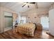 Cozy bedroom with wood-look floors, ceiling fan, and a mirrored closet for storage at 6731 Canterbury Ne Dr, Winter Haven, FL 33881