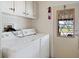 Functional laundry room featuring a washer, dryer, and a door to the backyard at 6731 Canterbury Ne Dr, Winter Haven, FL 33881