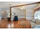 Open living room featuring wood beam, wood flooring, and view into the kitchen at 6731 Canterbury Ne Dr, Winter Haven, FL 33881