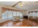 Cozy living room featuring wood floors, lots of natural light, and comfortable seating arrangement at 6731 Canterbury Ne Dr, Winter Haven, FL 33881