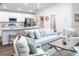 Bright, open-concept living room and kitchen with white cabinetry, stainless steel appliances, and modern decor at 702 Bentley North Loop, Auburndale, FL 33823