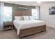 Serene main bedroom with a wooden headboard, soft lighting, and a view of the backyard at 702 Bentley North Loop, Auburndale, FL 33823