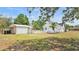Spacious backyard with lush grass and a detached garage, creating a serene and private outdoor space at 725 Avenue B Sw, Winter Haven, FL 33880