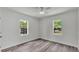 Bedroom with two windows, light gray wood flooring, and crisp white walls, offering a bright and airy feel at 725 Avenue B Sw, Winter Haven, FL 33880
