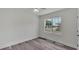 Cozy bedroom with wood-look flooring, neutral walls, and a large window at 725 Avenue B Sw, Winter Haven, FL 33880