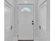 Inviting entryway featuring a white front door with a half-round window and neutral wall tones at 725 Avenue B Sw, Winter Haven, FL 33880