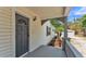 Inviting front porch with gray railing, a charming entrance, and a glimpse of the lush surroundings at 725 Avenue B Sw, Winter Haven, FL 33880