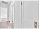 Hallway with light gray wood flooring, white trim, and white doors, offering a clean and bright transitional space at 725 Avenue B Sw, Winter Haven, FL 33880