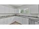 Bright, remodeled kitchen featuring white cabinets, stainless steel appliances, and granite countertops at 725 Avenue B Sw, Winter Haven, FL 33880