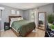 Well-lit bedroom featuring tile flooring, modern decor, large mirror, and comfortable queen bed at 790 Chelsea Way, Lake Wales, FL 33853