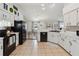 Kitchen with black appliances, white cabinets, and an open plan that flows into the dining area at 790 Chelsea Way, Lake Wales, FL 33853